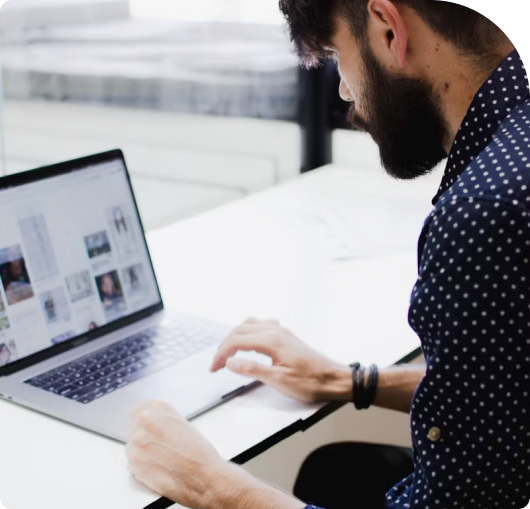 Bearded office
        worker tipes at laptop.